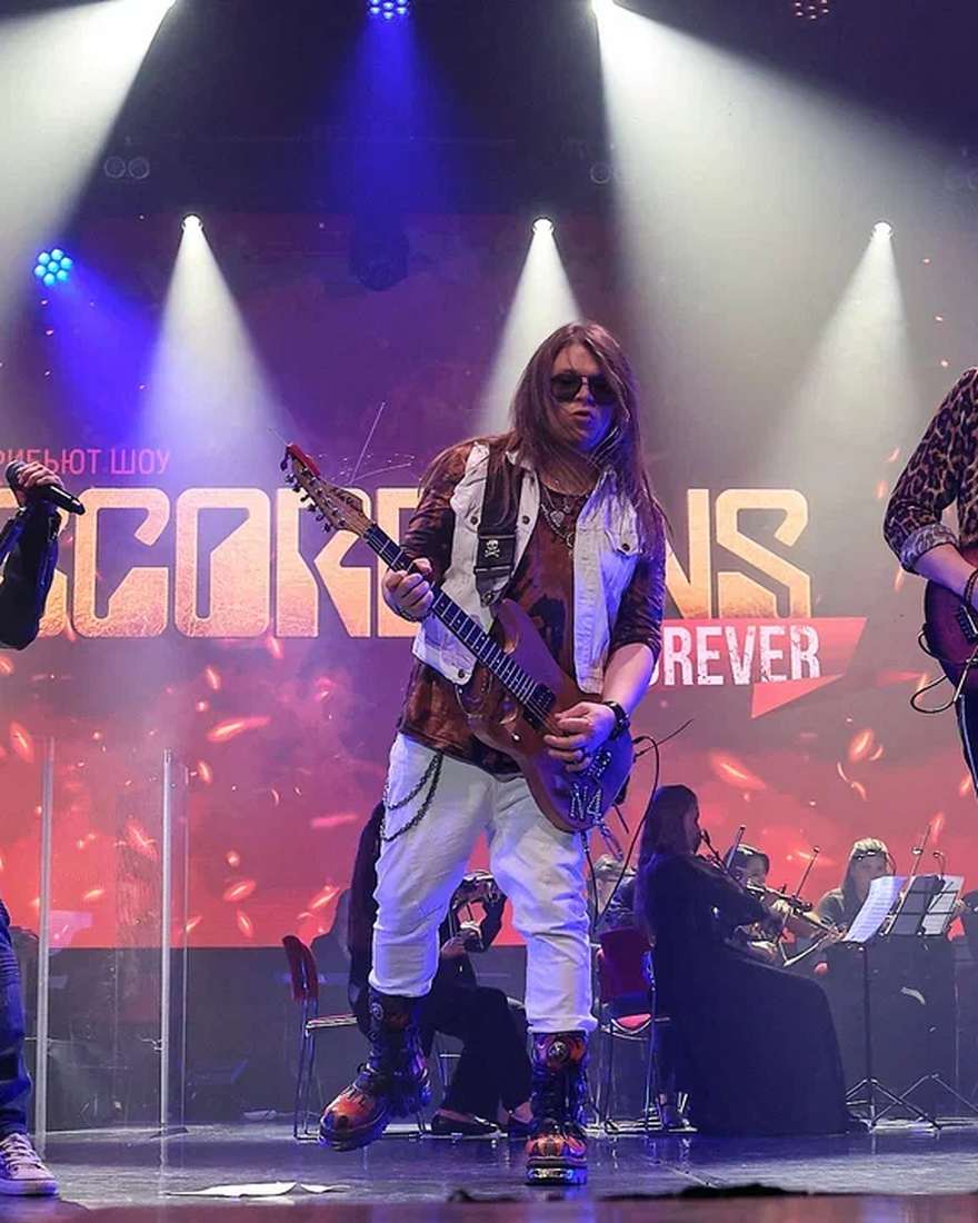 Гитарист Rock Believers на фоне баннера Scorpions Forever
